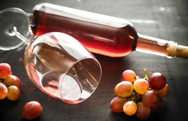 бутылка виноградного вина с бокалом на столе