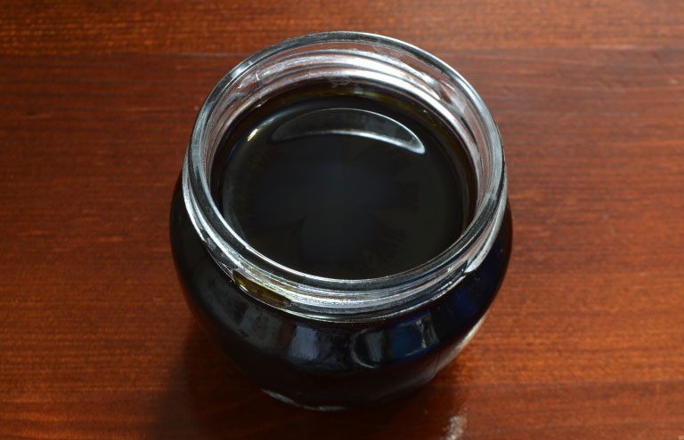масло чистотела в стеклянной баночке на столе